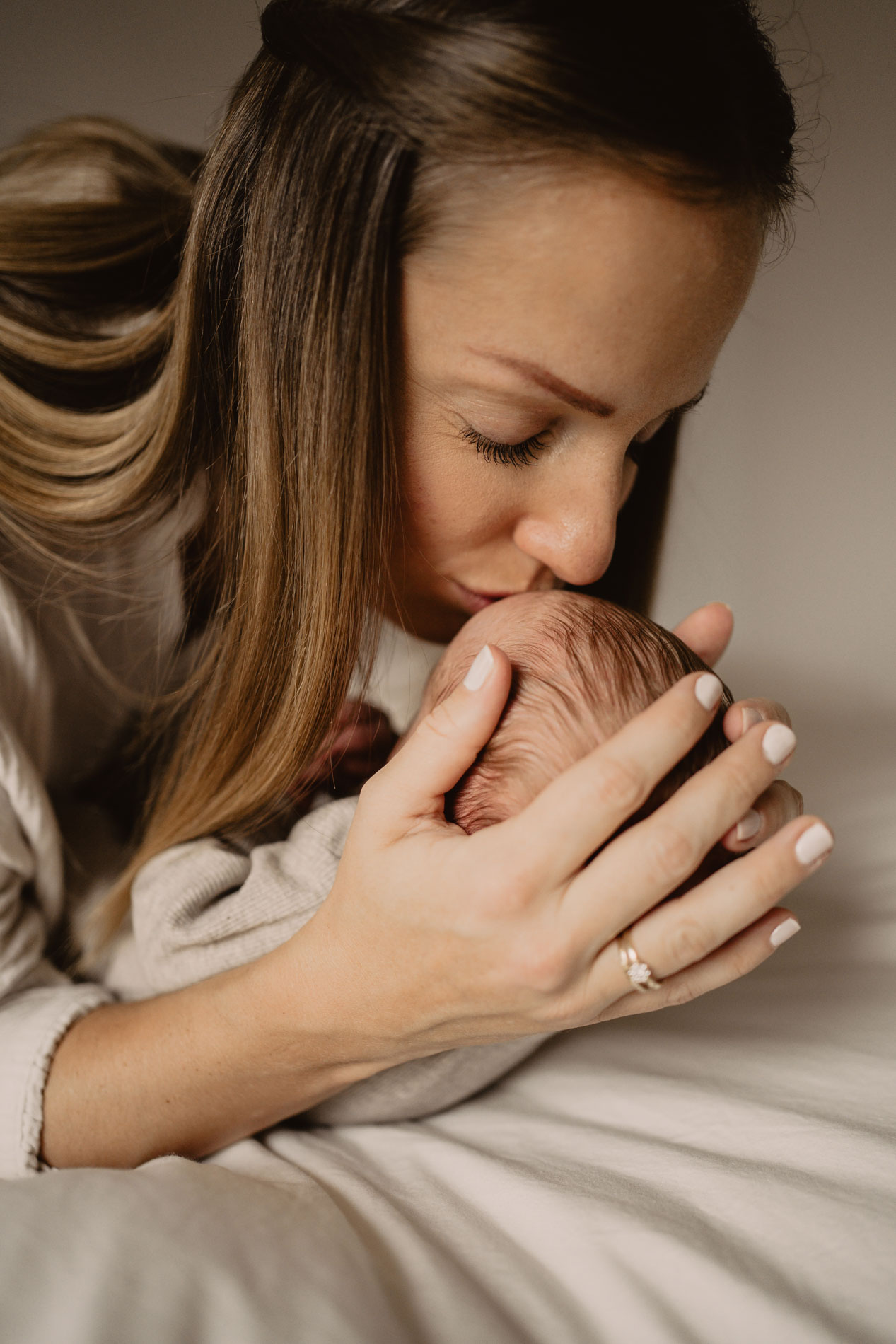 Mama  küsst liebevoll ihr Baby auf die Stirn